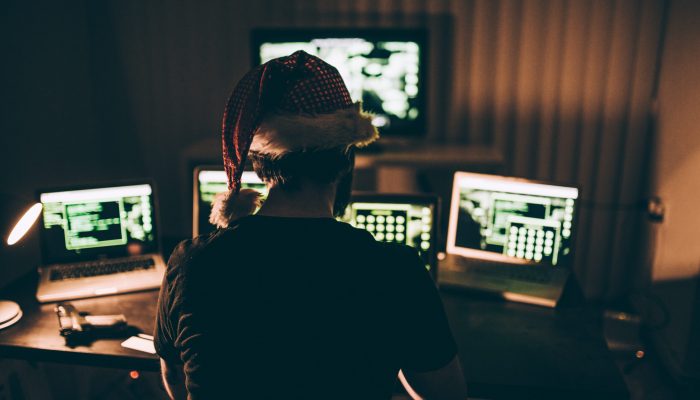 Holiday crime Computer hacker wearing santa hat while working on laptop late at night